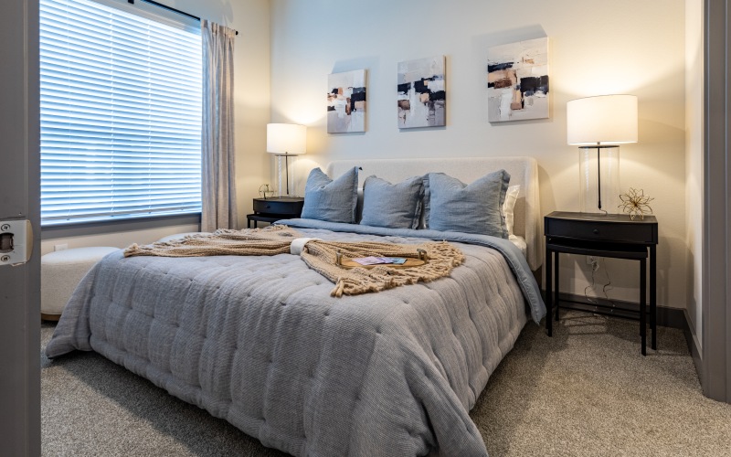 a bedroom with a bed and lamps