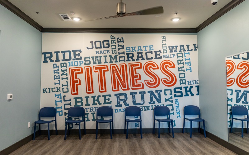 Fitness center with large mirror and hardwood floors