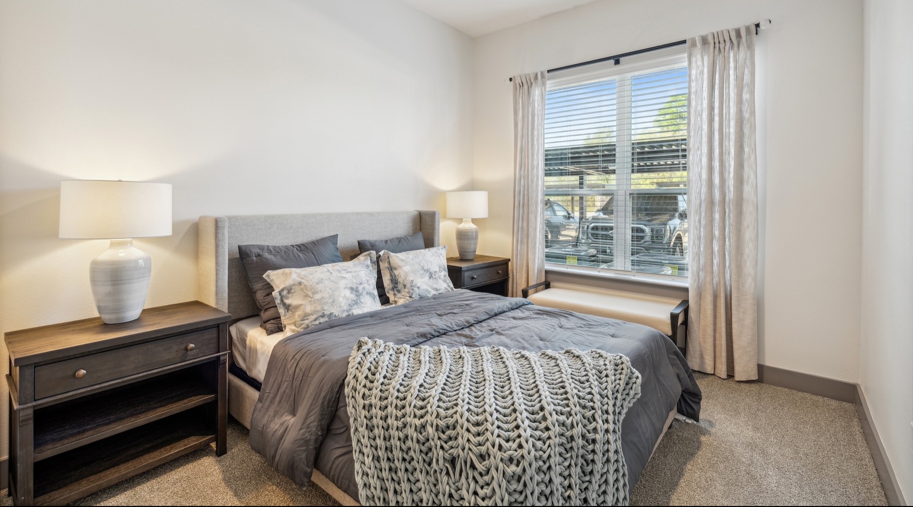 bedroom with night stands, lamps and large windows