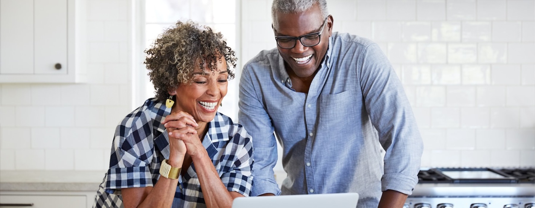 elderly couple looking at a computer together